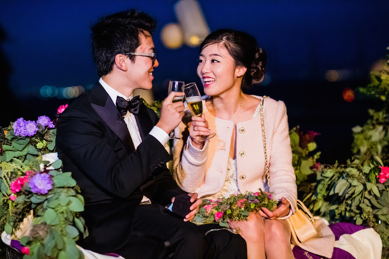 Couple celebrating together with champaign and sitting along flowers