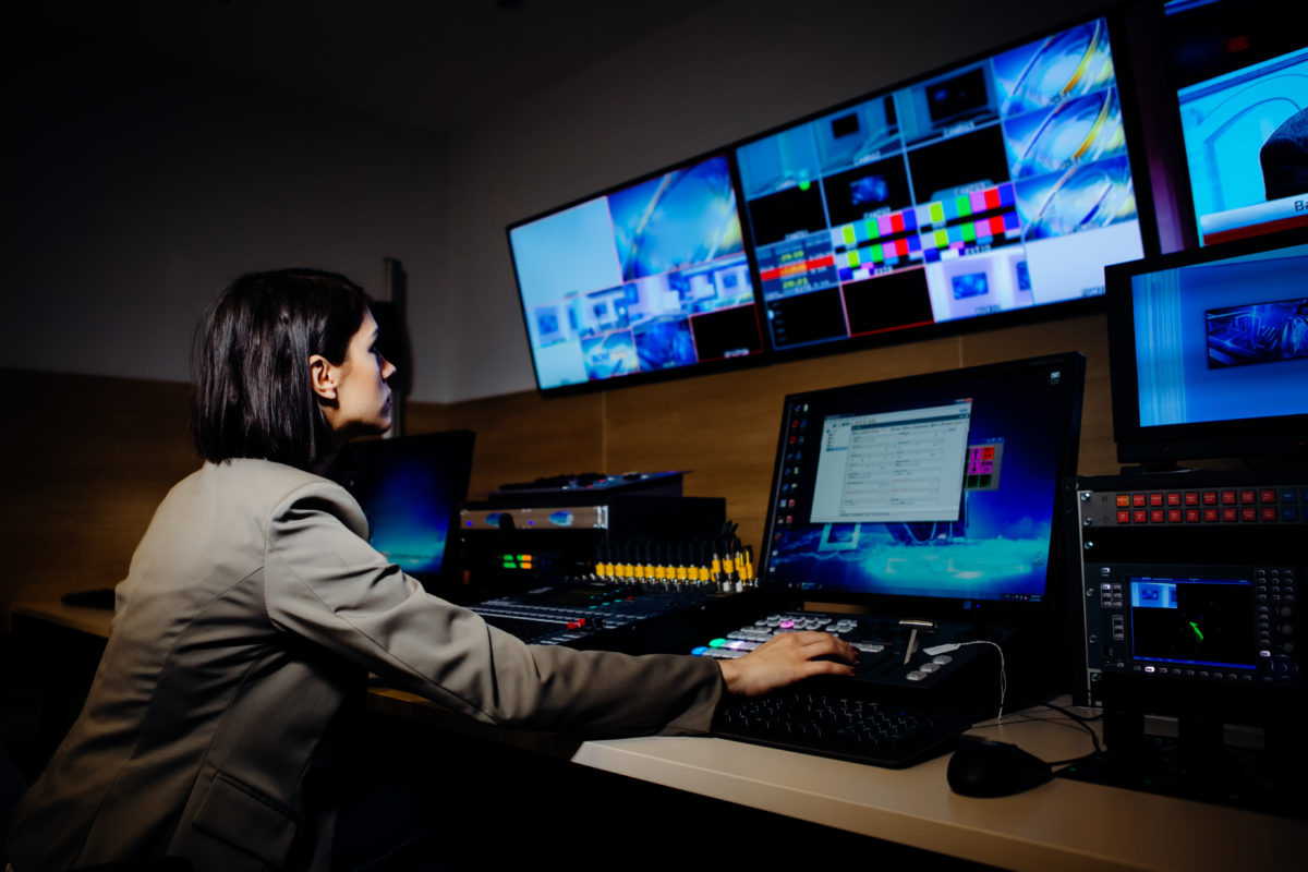 Female TV director control editing room in television studio.Operating vision mixer console equipment in a broadcast panel gallery.Realtime graphic engineer editor.Breaking news headline.Live stream