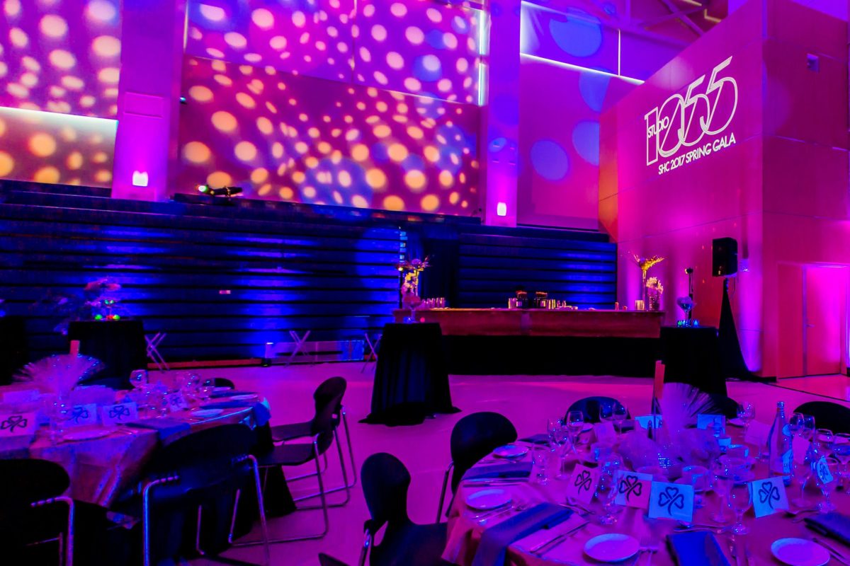 Event dining set-up with circle pattern wash lighting on the walls for non-profit event
