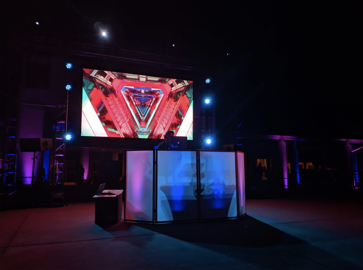Digital screen backdrop lighting for DJ booth at social event