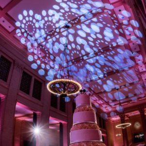 ceiling wash patterned lighting and cake table set-up for wedding